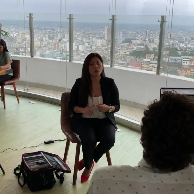 Detrás de cámaras: Cynthia Chacón grabando una entrevista frente al skyline de Guayaquil